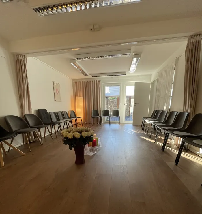 Stuhlkreis im Gruppenraum mit Rosen in der Mitte